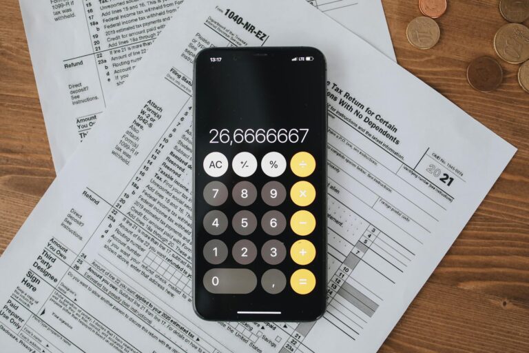 tax forms with calculator on wooden surface